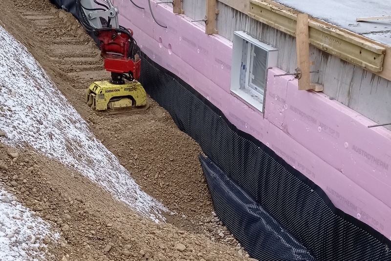 Vertical dimpled membrane waterproofing on a basement wall